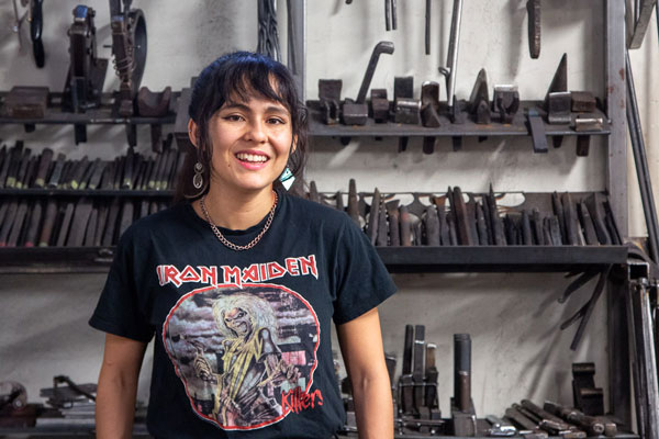 Amber Velez in front of a rack of metal-working tools
