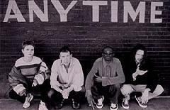photo of Faithless sitting in front of a brick wall with word ANYTIME painted on it