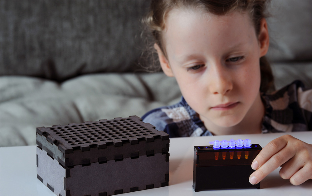 a photograph of a child examining a synthetic biology kit