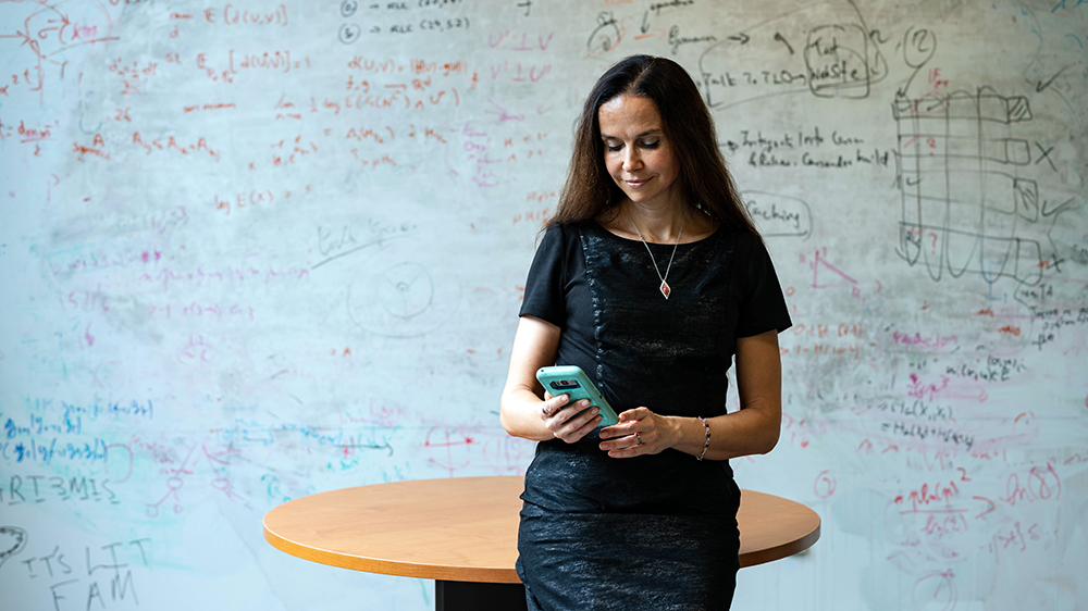An image of Muriel Medard looking at her smartphone