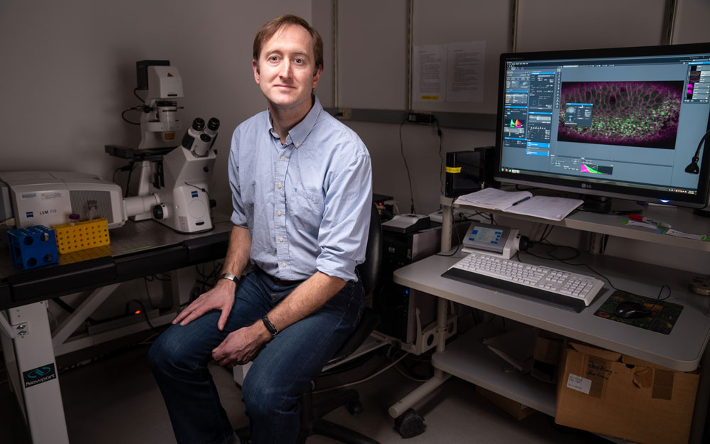 Biologist Adam Martin sitting in his office at MIT