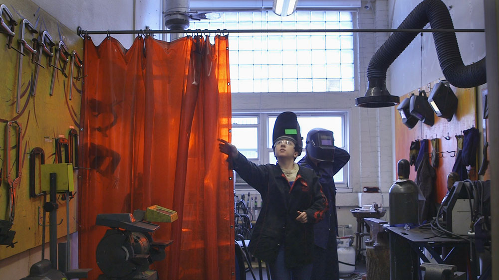 An image of a student drawing back a curtain, a still from today's video 