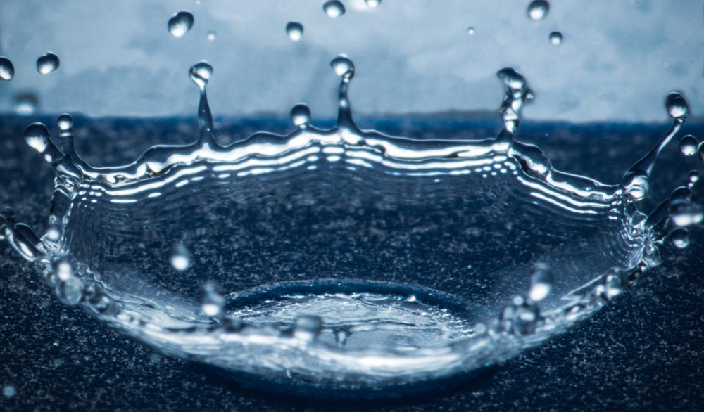 a droplet striking a solid surface and splashing upon impact