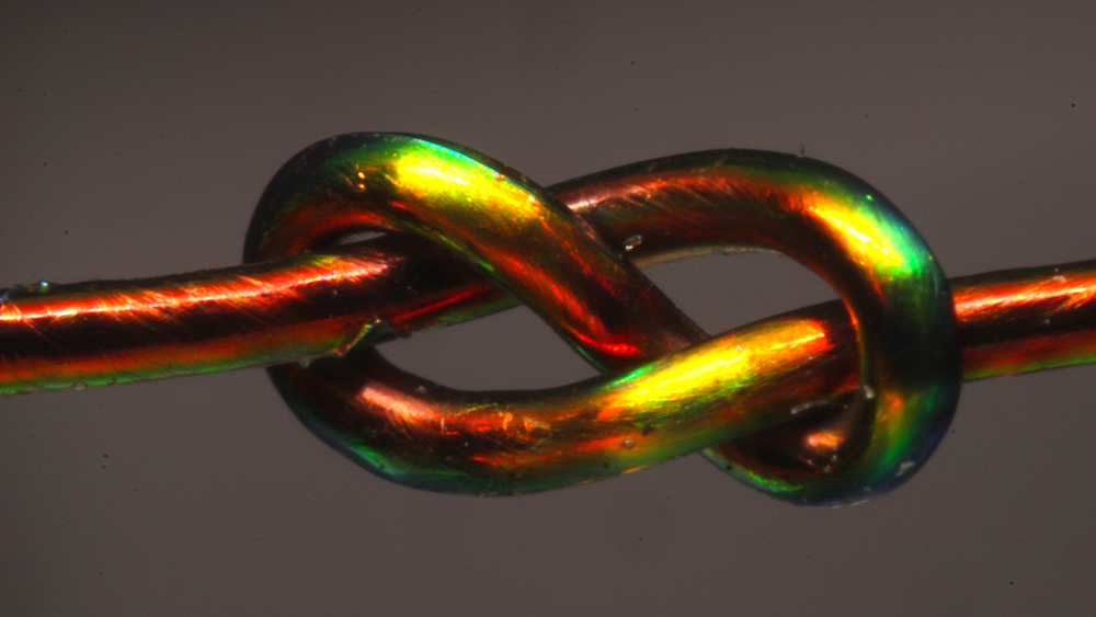 a closeup of a knot tied in a piece of metalic thread