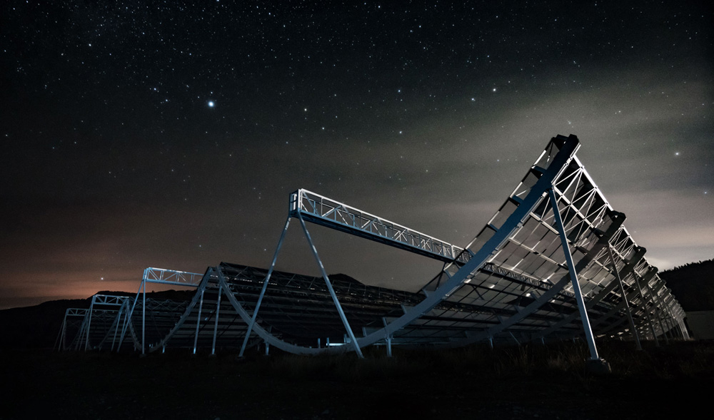 a nighttime photograph of the 4 radio antennas that make up CHIME