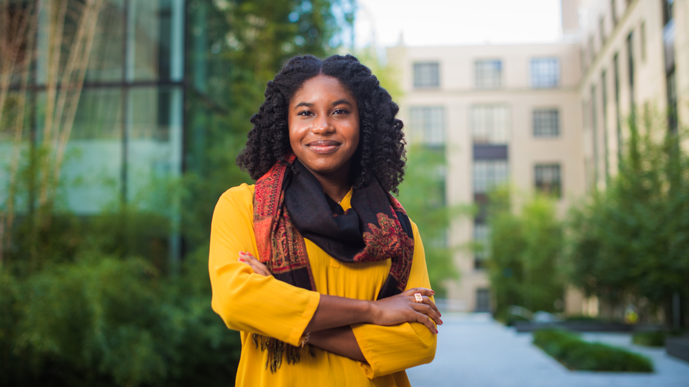 Danielle Grey Stewart outside in yellow, showing brass rat ring. Photo by Gretchen Ertl
