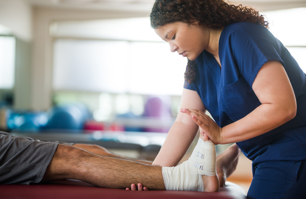 a physical therapist working on a patient's foot