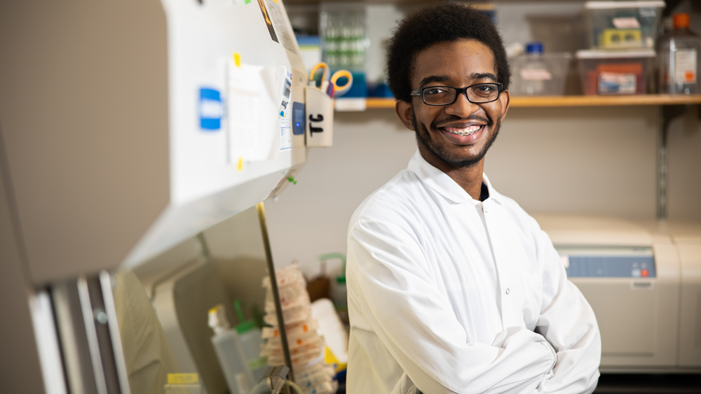 Photo of Desmond Edwards, arms crossed, in the lab