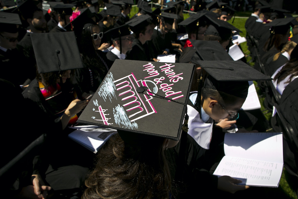 At Commencement, a graduate’s mortarboard is decorated with the words, “Thanks, Mom and Dad!” and an illustration of the Great Dome and crew boat on the Charles.