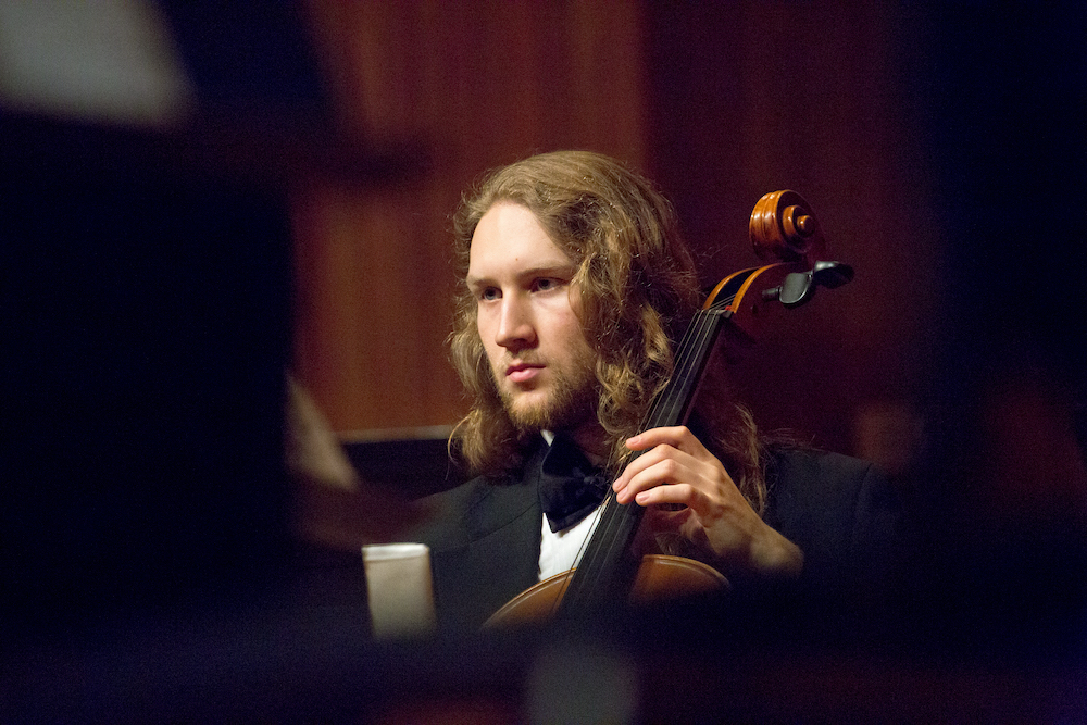 Student musician plays a cello.