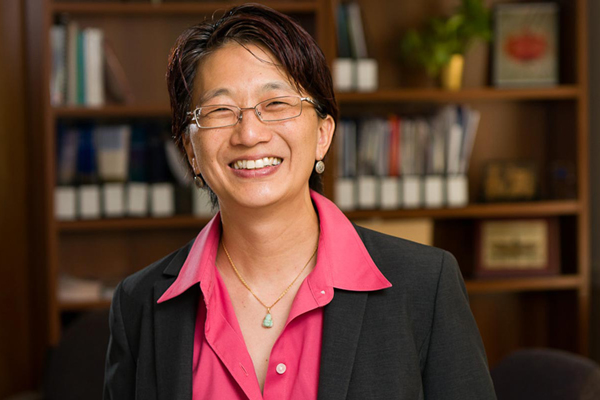 Julie Chen in front of a shelf full of books