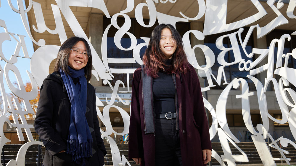 Adela (YiYu) Zhang ’18, left, and Jakin Ng ’25 inside The Alchemist sculpture