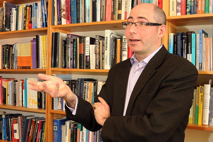 Photo of David Kaiser with filled bookshelf in background