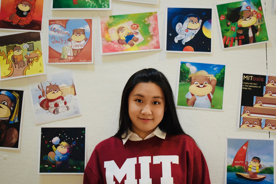 Tianyuan (Margaret) Zheng in front of a wall filled with Wide Tim illustrations