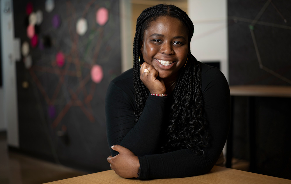 Mercy Oladipo smiles while her hand rests on her chin and she wears her Brass Rat ring.