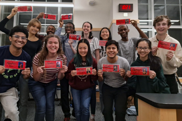 a group of students holding red name cards