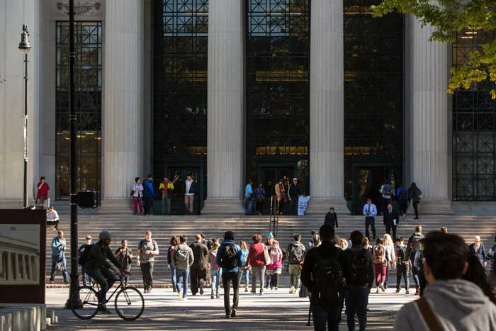 People cross Mass Ave., with Lobby 7 columns and stairs in background