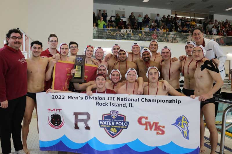 About 20 team members and their coaches pose for a photo in front of a banner that says, Men'sDivision III National Championship; Rock Island, IL."