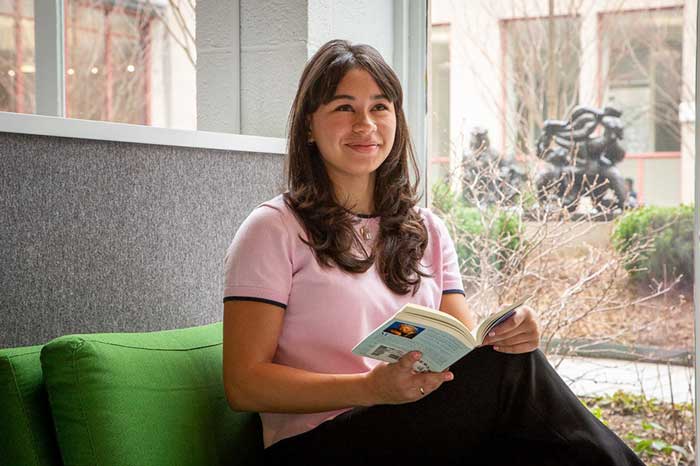 Grace McMillan is photographed while reading a book on a couch