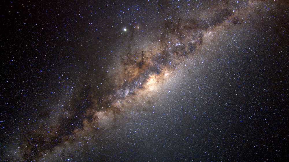 The Milky Way streaks across the image diagonally, glowing with celestial bodies