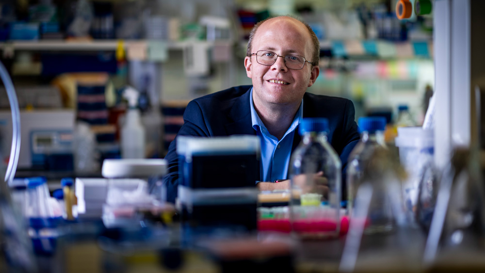 Michale Birnbaum in the lab with blurry equipment in foreground