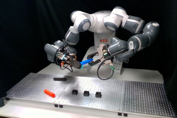 A robotic arm picks objects from the table in a lab test
