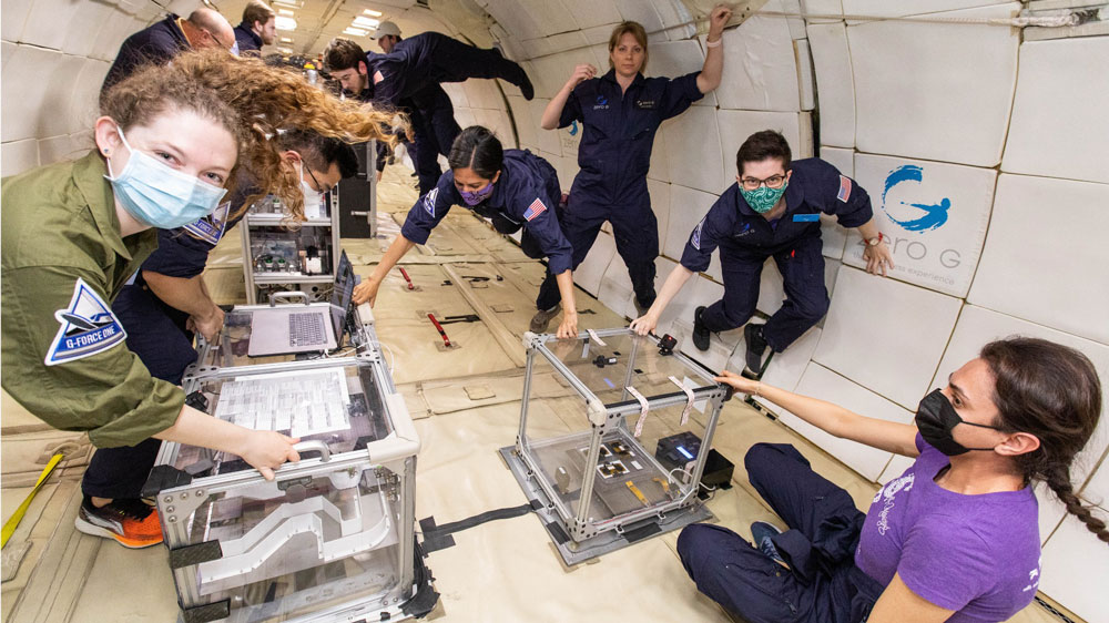 people in Zero gravity float while working on a project