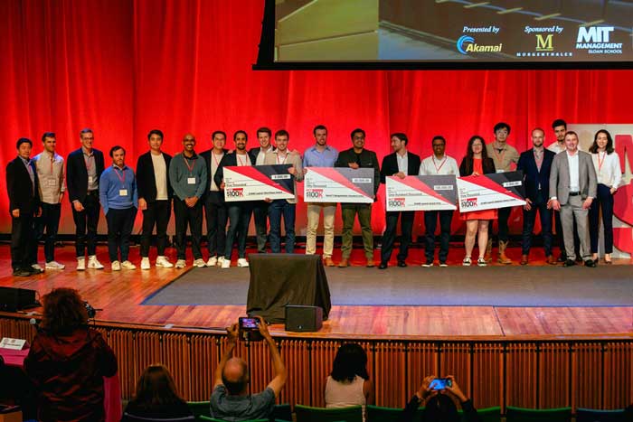 Group of winners on stage with 4 large checks