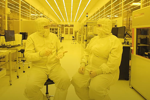 two people in a clean room dressed in protective gear