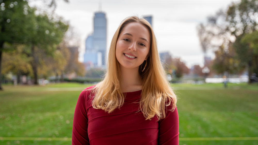 Julia Schneider in Killian Court with Boston skyline