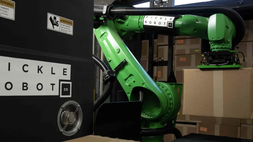 Green robot arm picks up large cardboard boxes