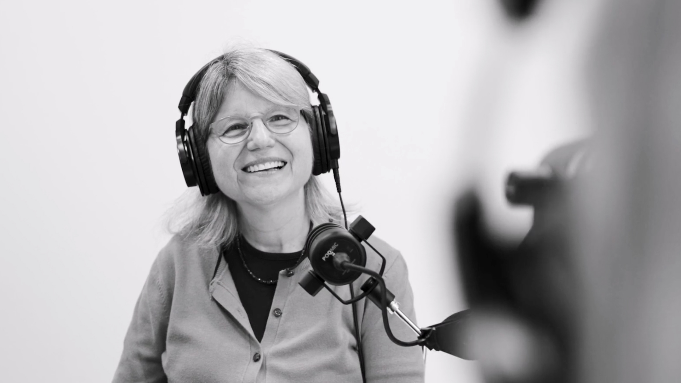 Sally Kornbluth sitting at a microphone