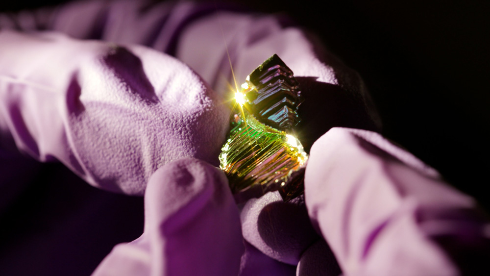 hands holding a piece of Bismuth