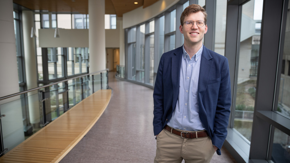 Emil Verner stands near windows in Sloan