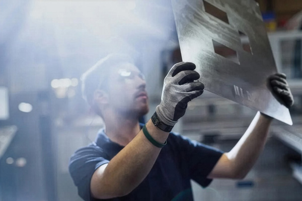 a worker examining a sheeting of metal