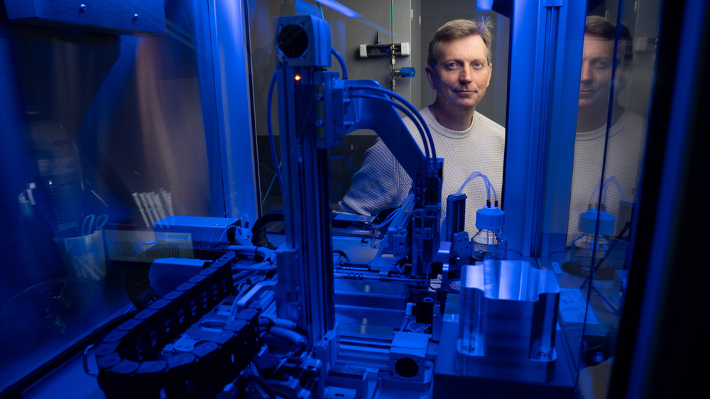 Joey Davis peers through a blue-lit machine