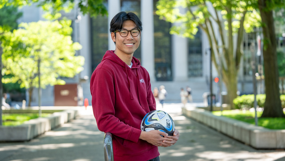 Henry Wang with soccer ball on campus