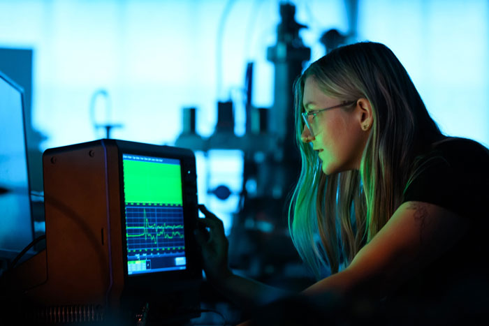 Lanie McKinney looks at oscilloscope 