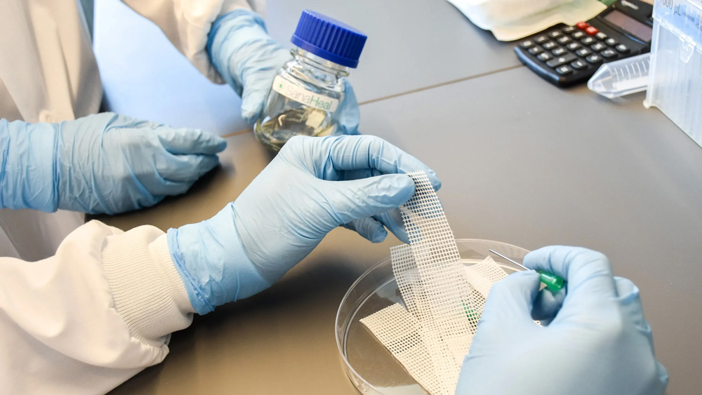 gloved hands work with a new gauze strip adhesive