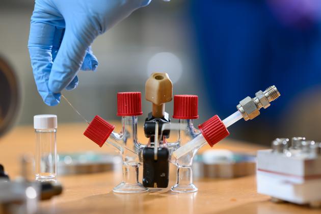 An H-cell modified with electrodes and an ion-conducting ceramic membrane to conduct sodium-air fuel cell experiments.