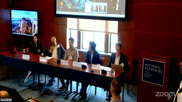 The panel table, left to right: Carina Hong, David Spergel, Ralph Abboud, Shida Wang, and moderator Brendan Hassett. The session used no slides at any point — this wide shot and the name placards are its entire visual record.